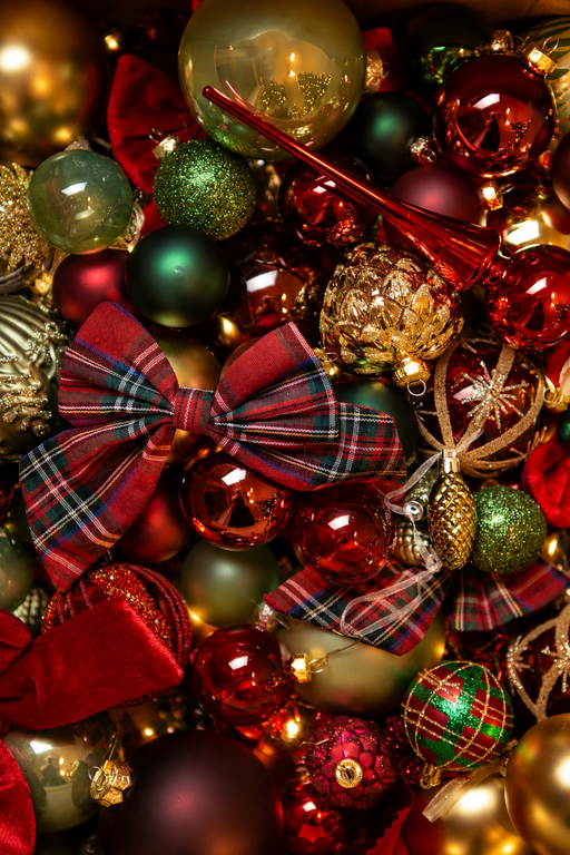 Overzicht van het kerstdecoratiepakket A Christmas Heritage met rode, groene en gouden kerstballen, Schots geruite strikken en feestelijke kerstversiering.