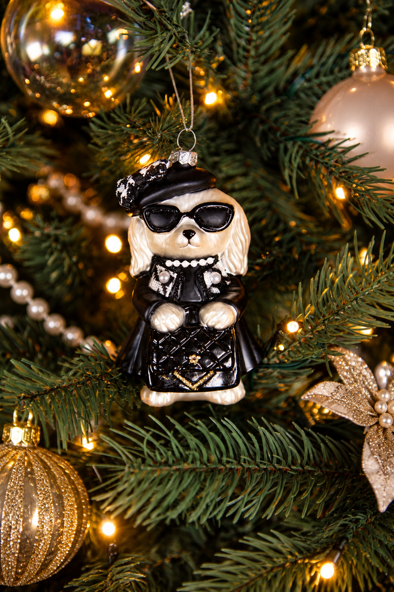 Detail van Christmas Couture kerstboomversiering met een modieuze kerstengel met zonnebril en zwarte outfit, gouden kerstballen en warme kerstverlichting.
