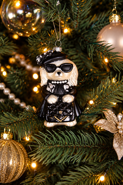 Detail van Christmas Couture kerstboomversiering met een modieuze kerstengel met zonnebril en zwarte outfit, gouden kerstballen en warme kerstverlichting.