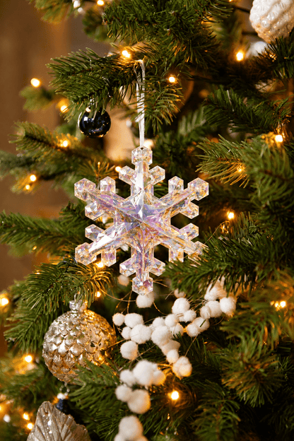 Detail van Snow White Christmas kerstboomversiering met een transparante sneeuwvlokhanger, zilveren kerstbal, witte besjes en warme kerstverlichting.